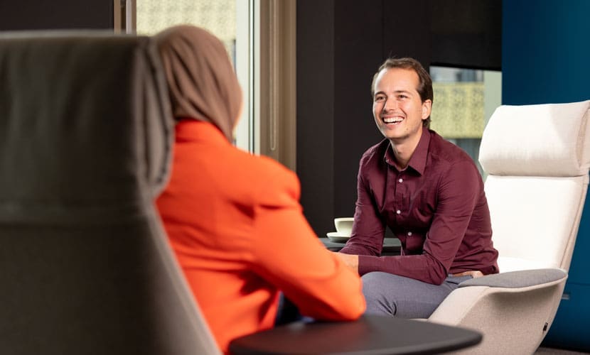 Twee medewerkers lachen samen op kantoor