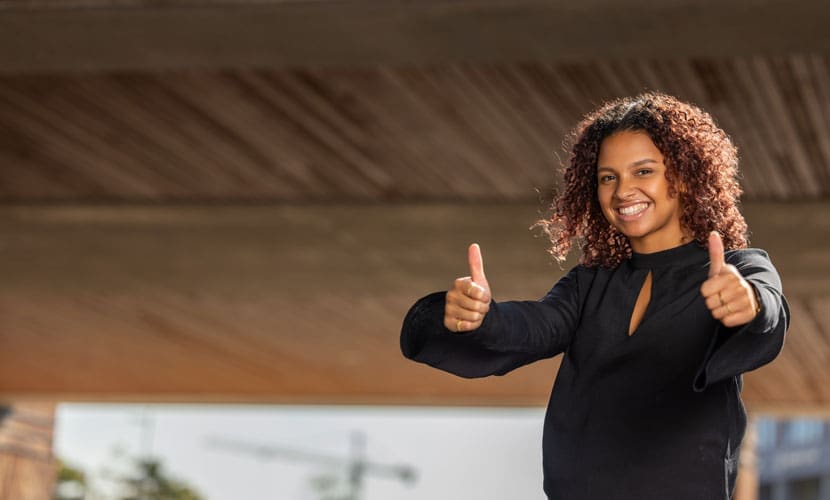 Portretfoto van vrouw die beide duimen opsteekt