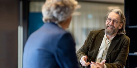 twee mannen met elkaar in gesprek aan een staantafel