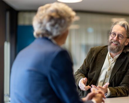 twee mannen met elkaar in gesprek aan een staantafel