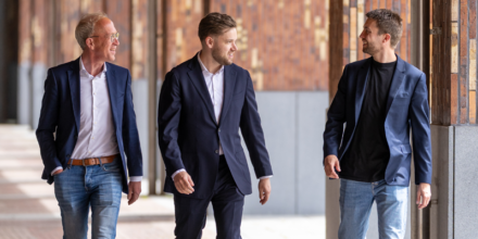 Drie collega's zijn buiten tijdens een wandeling met elkaar in gesprek