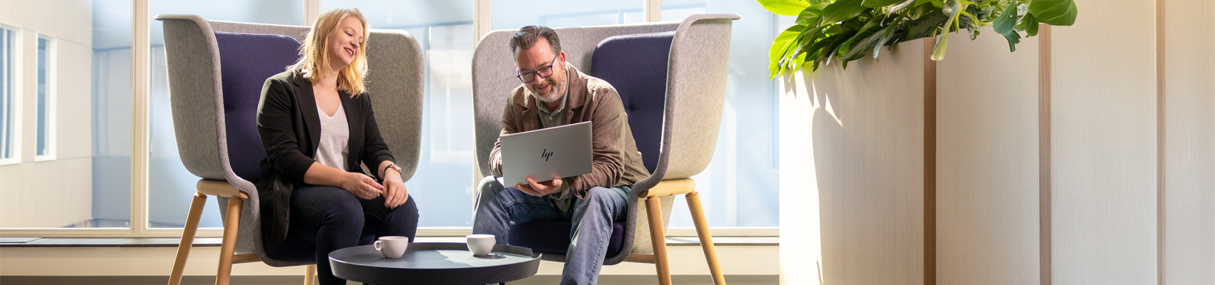 Twee collega's zijn in gesprek met elkaar achter één laptop