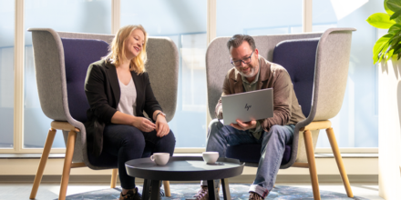 Twee collega's zijn in gesprek met elkaar achter één laptop