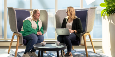 Twee collega's zijn in gesprek met elkaar achter één laptop