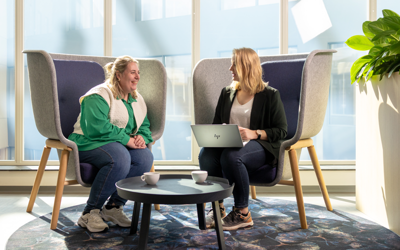 Twee collega's zijn in gesprek met elkaar achter één laptop