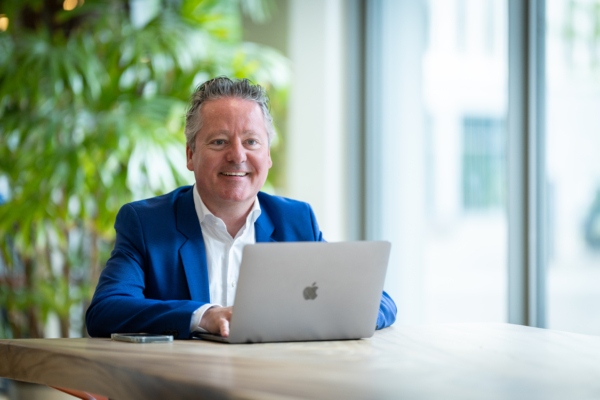 Collega werkt lachend achter laptop