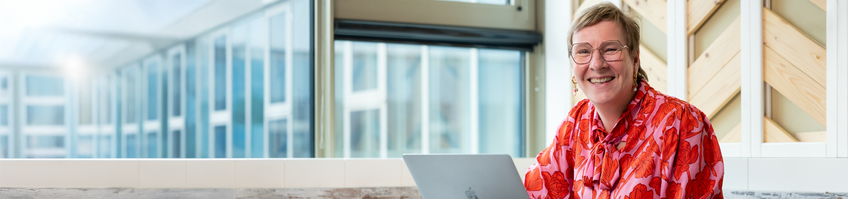 Medewerker lacht en werkt achter laptop