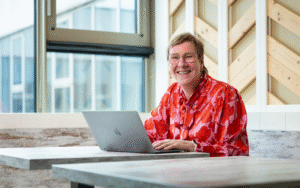 Medewerker lacht en werkt achter laptop