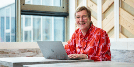 Medewerker lacht en werkt achter laptop