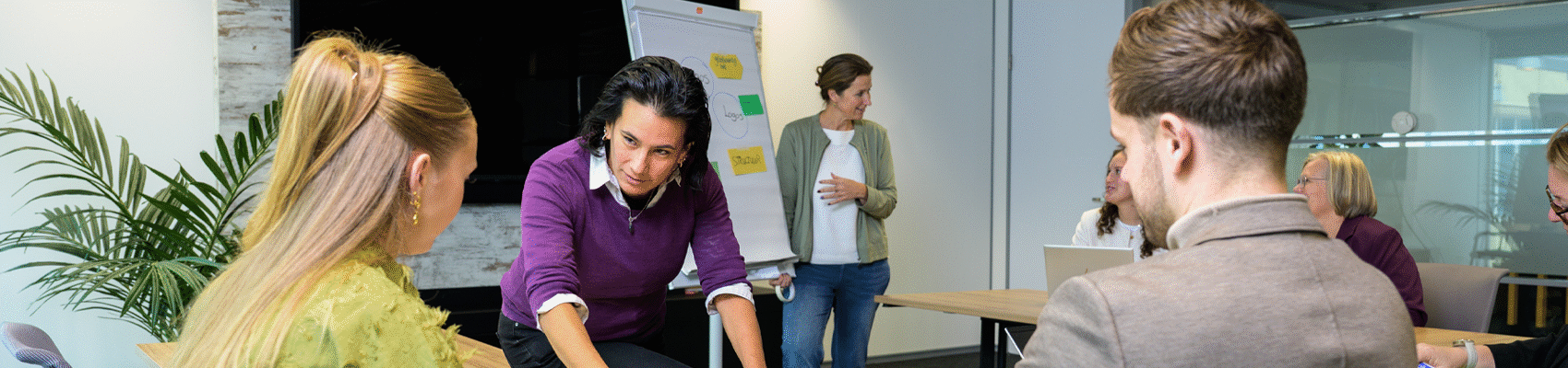 twee medewerkers geven training op kantoor aan cursisten