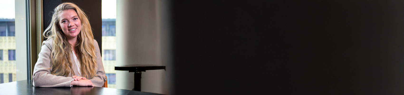 vrouw zit lachend aan tafel