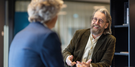 twee mannen met elkaar in gesprek aan een staantafel