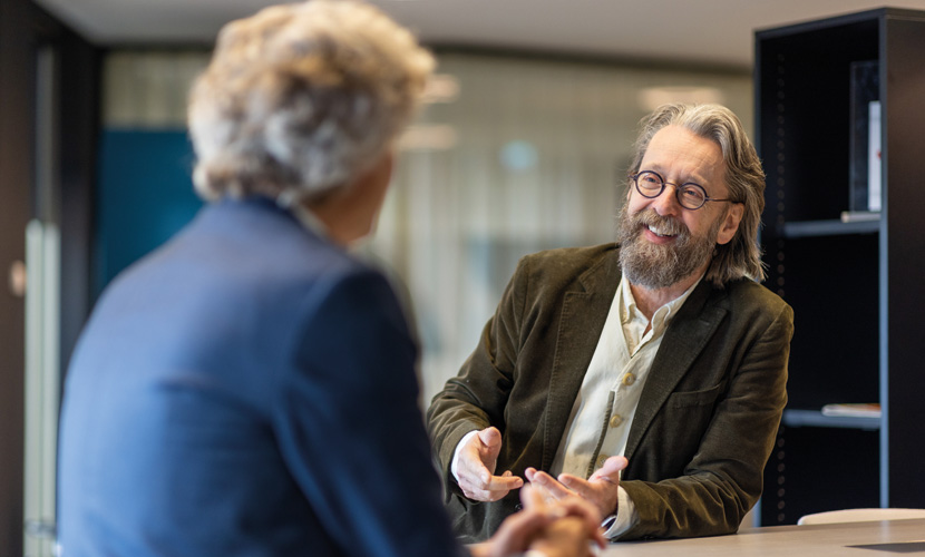 twee mannen met elkaar in gesprek aan een staantafel