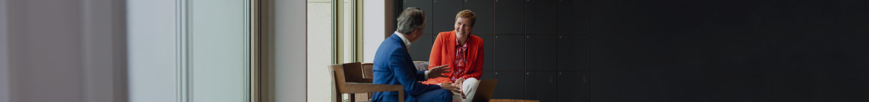 Twee collega's hebben een informeel gesprek op kantoor