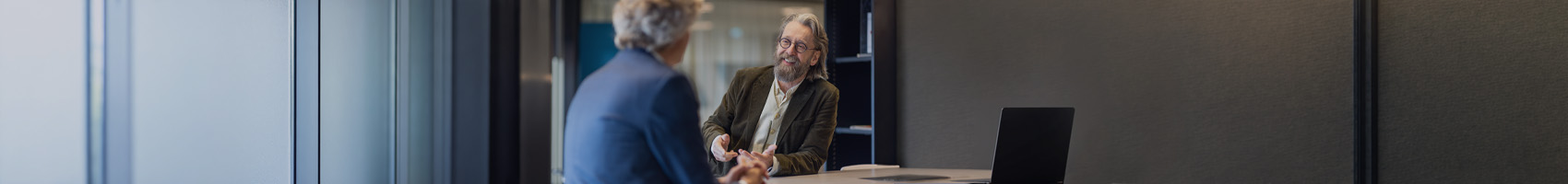 twee mannen met elkaar in gesprek aan een staantafel