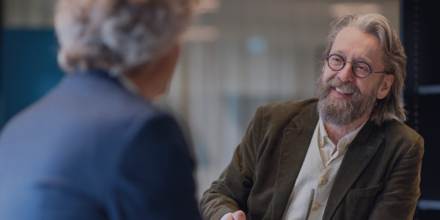 twee mannen met elkaar in gesprek aan een staantafel