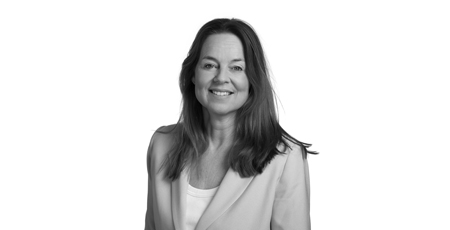 Black-and-white portrait photo of a smiling woman wearing a blazer.