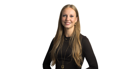 Color portrait photo of a smiling woman wearing a black long-sleeve top.